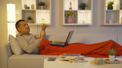 Man-dancing-while-lying-down-and-using-laptop.
